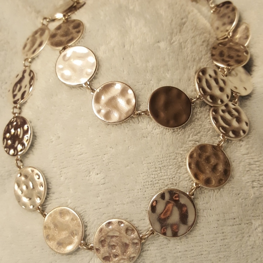 A shiny silver coin like necklace.